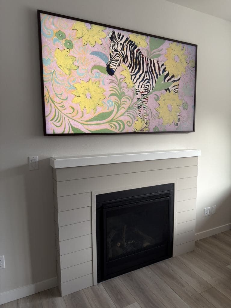 Frame TV installation over a shiplap fireplace