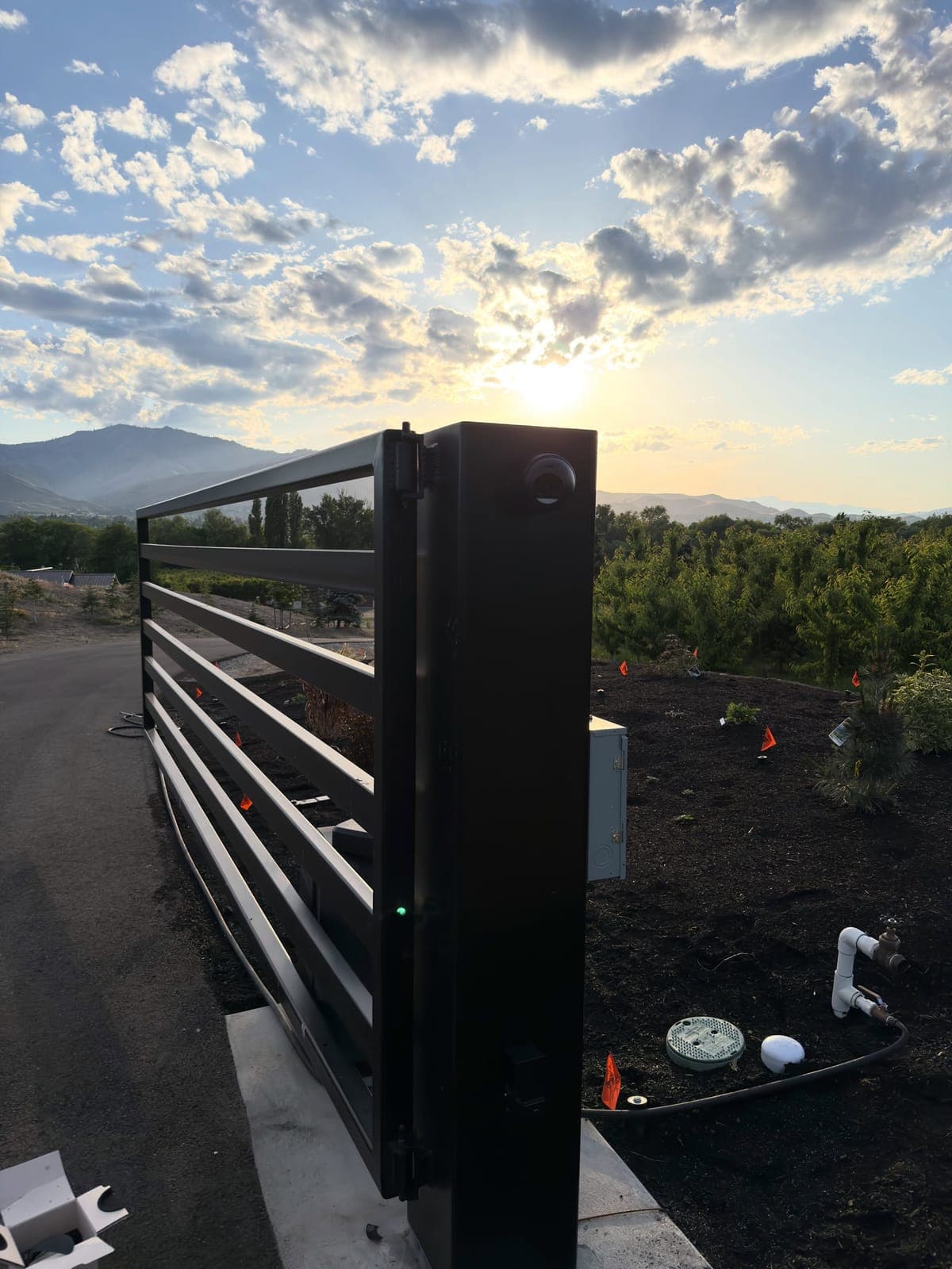 UniFi security camera on a driveway gate overlooking the orchards