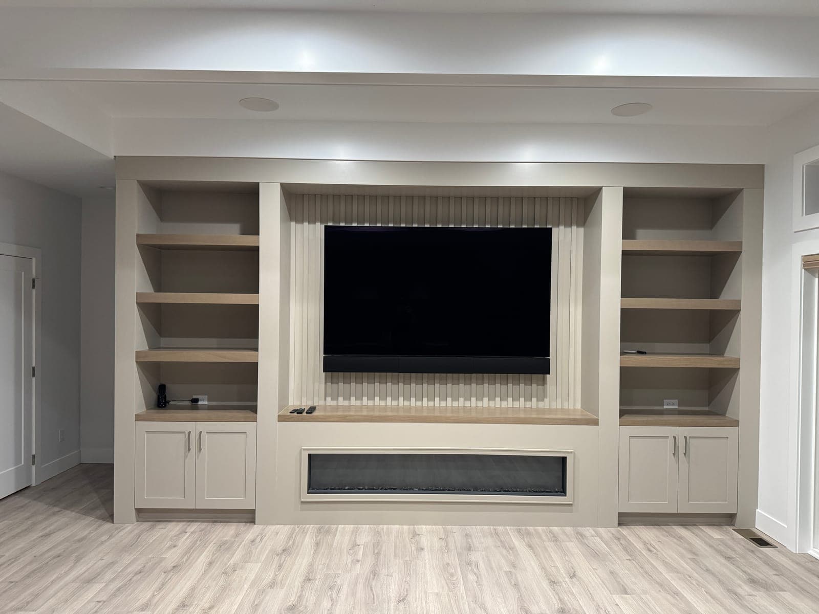 Media wall with TV and soundbar over a linear fireplace