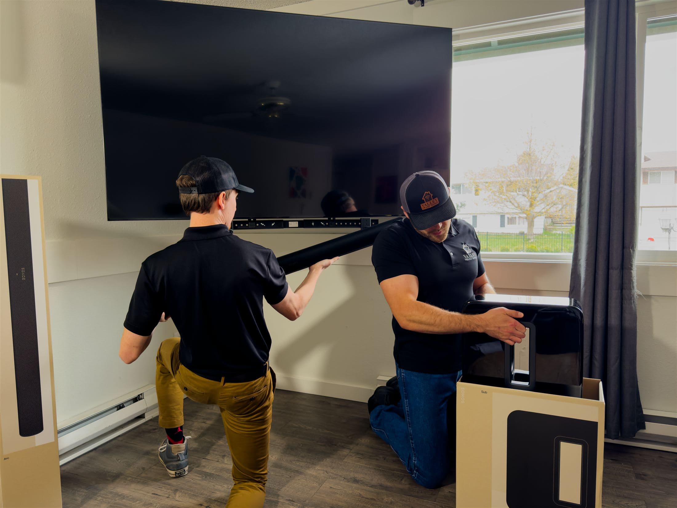 Valley Smart Homes technicians installing a TV and Sonos system